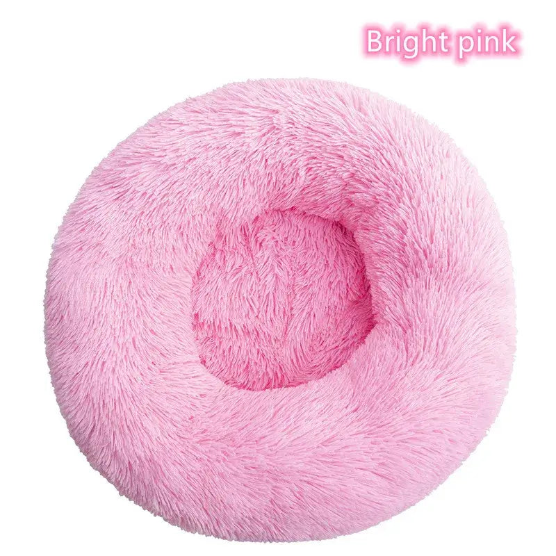 Bright pink round plush pet bed, ideal for small dogs and cats, providing a cozy and calming rest space.