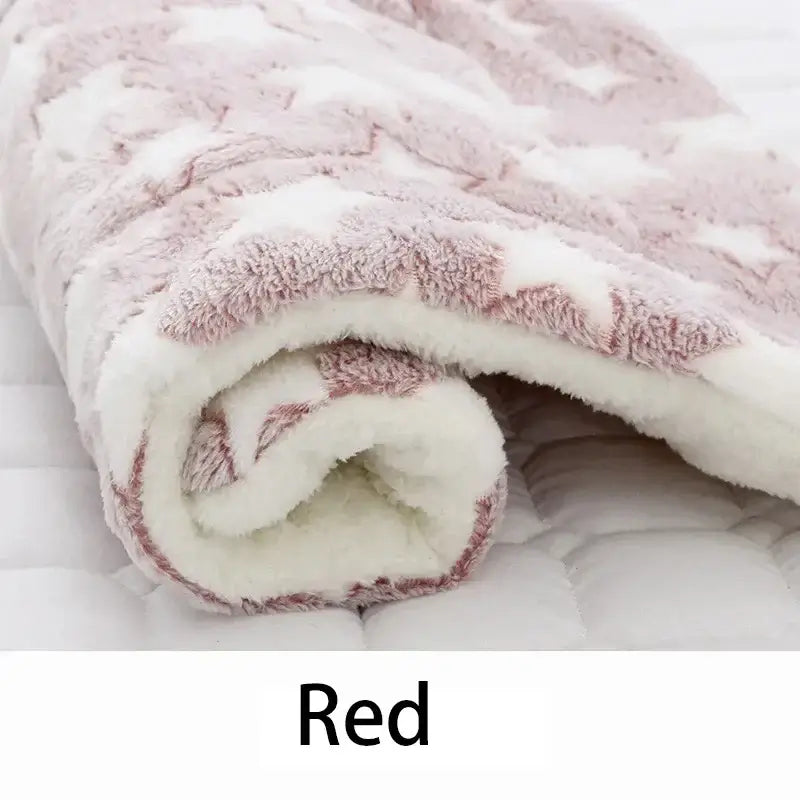 Soft red flannel pet blanket rolled up, featuring star pattern on plush coral velvet, perfect for cozy pet bedding.