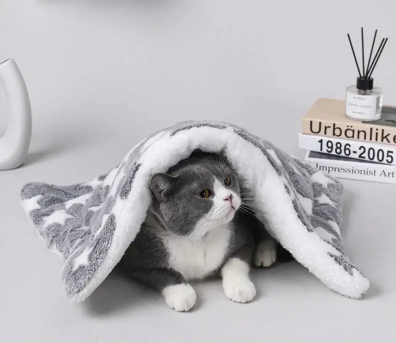 Cozy cat wrapped in a soft flannel pet blanket, providing warmth and comfort on a stylish surface.