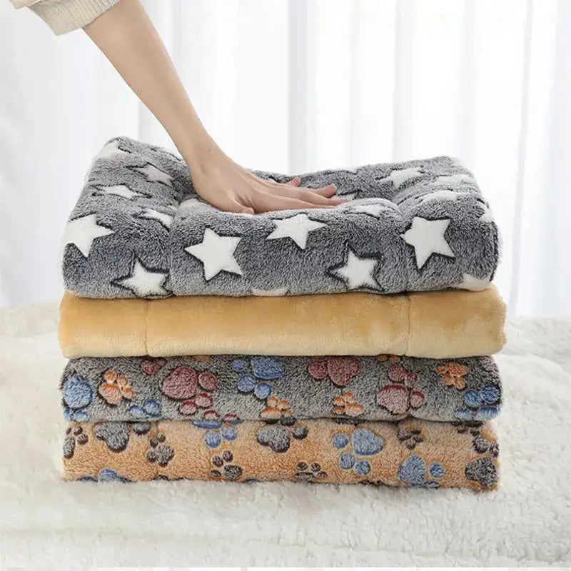 Stacked Paw-some Flannel Pet Sleeping Mats in gray, tan and brown with star and paw prints designs.