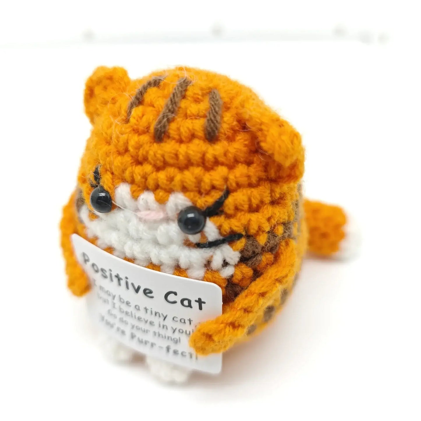 Handmade crochet orange cat doll with a positive message tag, perfect for home decor and gifting.