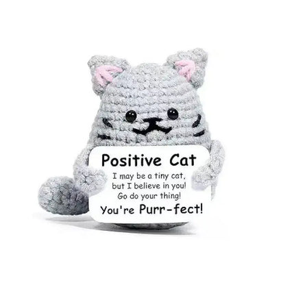 Handmade crochet gray cat doll holding a sign that reads 'Positive Cat' with an uplifting message.