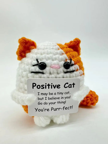 Handmade crochet cat doll with positive message, featuring a cute tiny cat holding a sign that reads 'You're Purr-fect'.