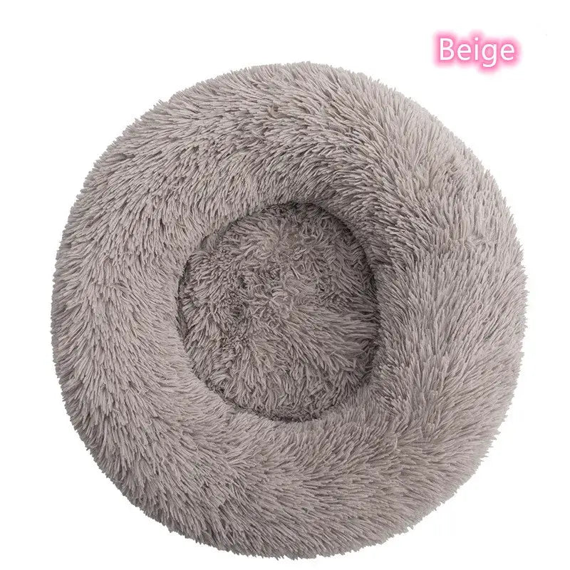 Beige round plush pet bed for dogs and cats, providing warmth and comfort for cozy naps and anxiety relief.