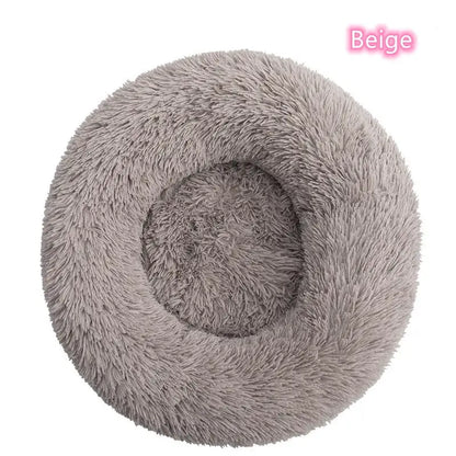 Beige round plush pet bed for dogs and cats, providing warmth and comfort for cozy naps and anxiety relief.